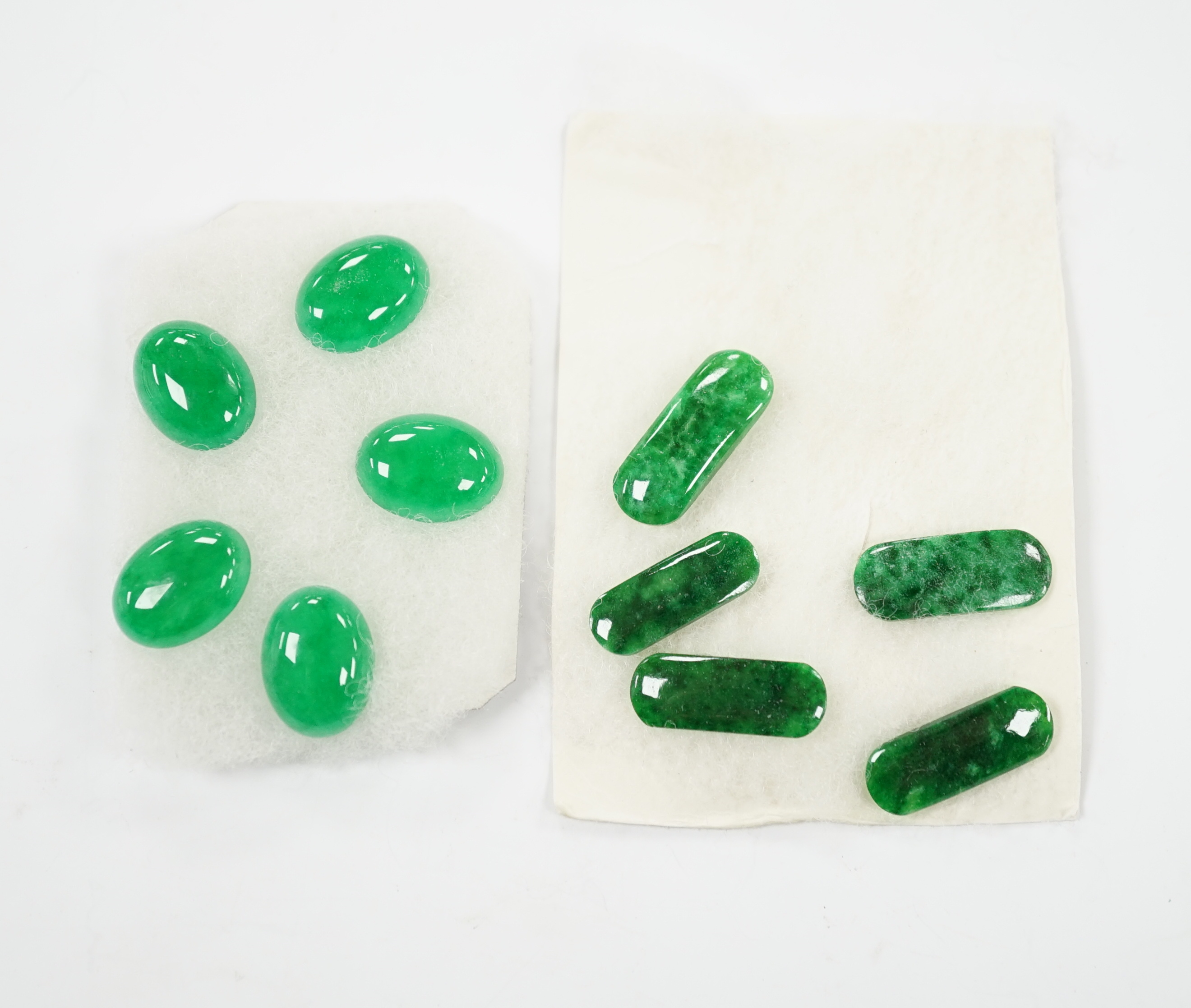 Five unmounted jadeite cabochons, approx. 15mm and five unmounted ovoid jadeite cabochons, approx. 22mm, (fixed to a card background).